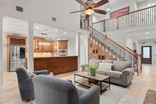 living room featuring visible vents, ornate columns, and a towering ceiling