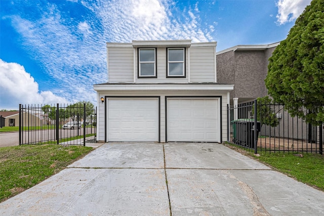 exterior space with fence, an attached garage, and driveway