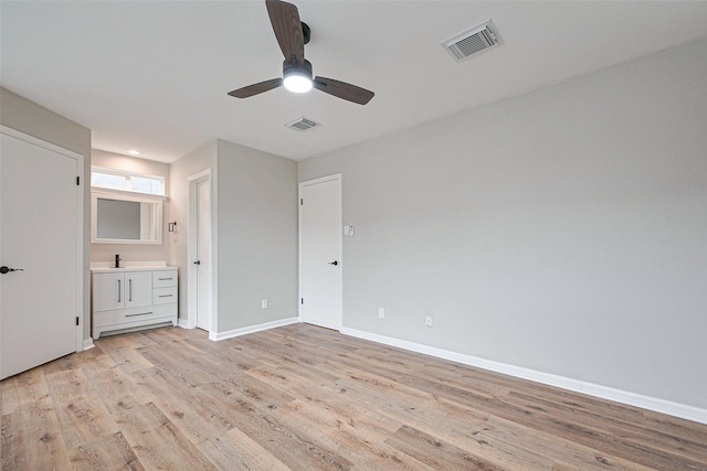 unfurnished bedroom with baseboards, visible vents, a sink, and light wood-type flooring