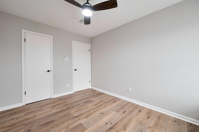 unfurnished bedroom with a ceiling fan, baseboards, and light wood-style floors