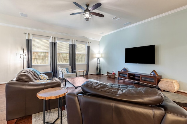 living room with crown molding, baseboards, visible vents, and wood finished floors