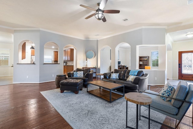 living area with arched walkways, baseboards, and ceiling fan