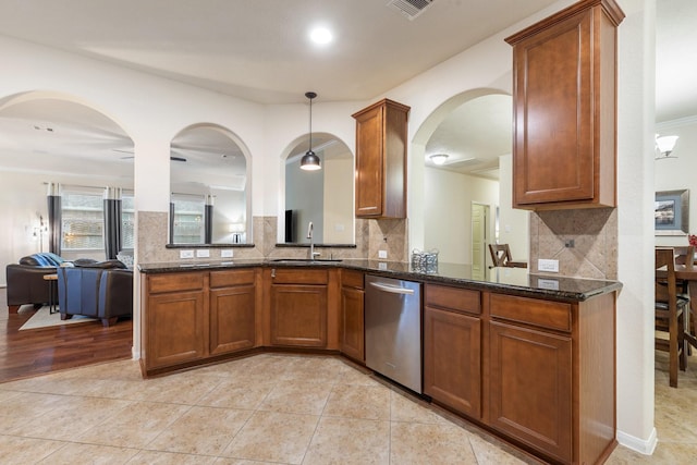 kitchen with stainless steel dishwasher, brown cabinets, and a sink