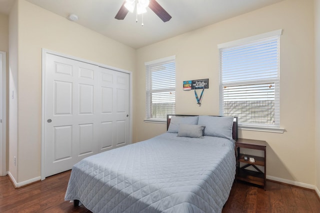 bedroom with baseboards, wood finished floors, and a closet