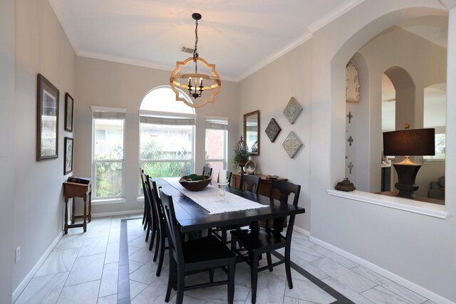 dining room with light marble finish flooring, healthy amount of natural light, a chandelier, and ornamental molding