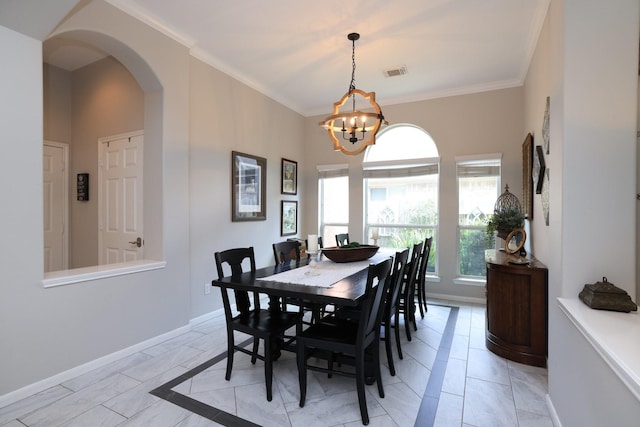 dining area with arched walkways, a chandelier, baseboards, and ornamental molding