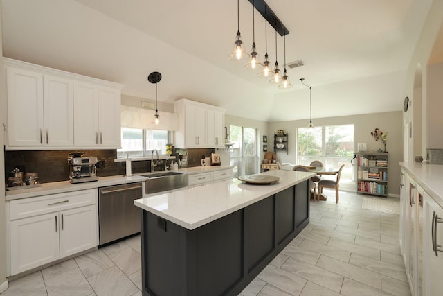 kitchen featuring dishwasher, a sink, light countertops, white cabinets, and decorative backsplash