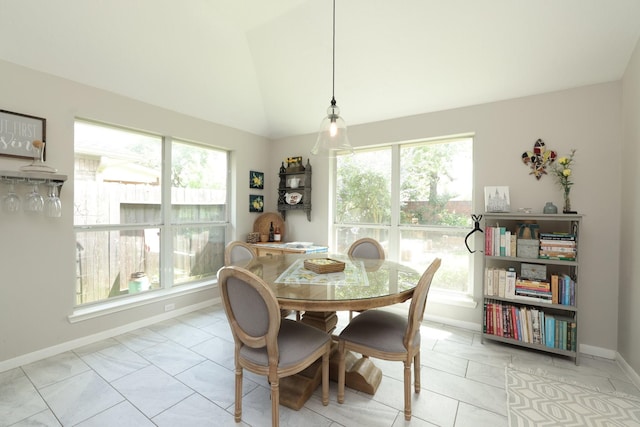 dining space with vaulted ceiling and baseboards