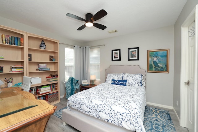 bedroom with baseboards, wood finished floors, and a ceiling fan