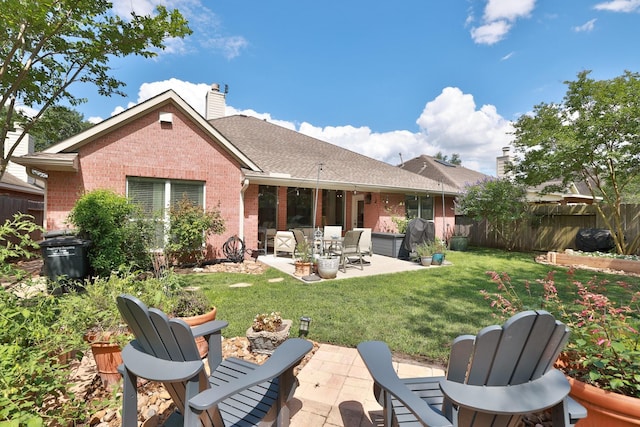 back of property featuring brick siding, a chimney, and a patio
