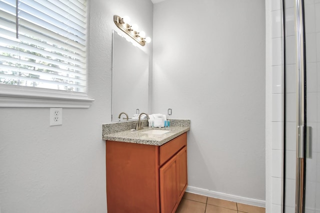 8102 Rhobell St, Houston, TX 77078 - full bathroom featuring vanity, baseboards, a shower with shower door, and tile patterned floors