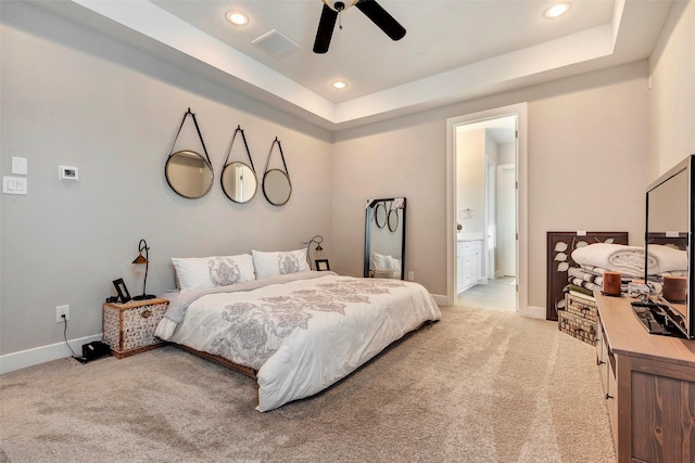 bedroom with light colored carpet, baseboards, a tray ceiling, and visible vents