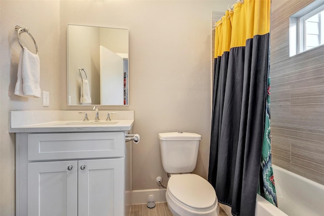 bathroom featuring vanity, baseboards, shower / bath combo, and toilet