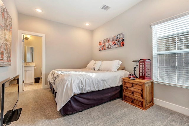 bedroom with visible vents, baseboards, recessed lighting, light colored carpet, and connected bathroom