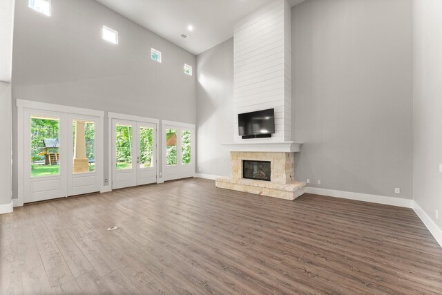 26111 Upper Beacon Pl, Montgomery, TX 77316 - unfurnished living room with a high ceiling, a fireplace, recessed lighting, baseboards, and wood finished floors
