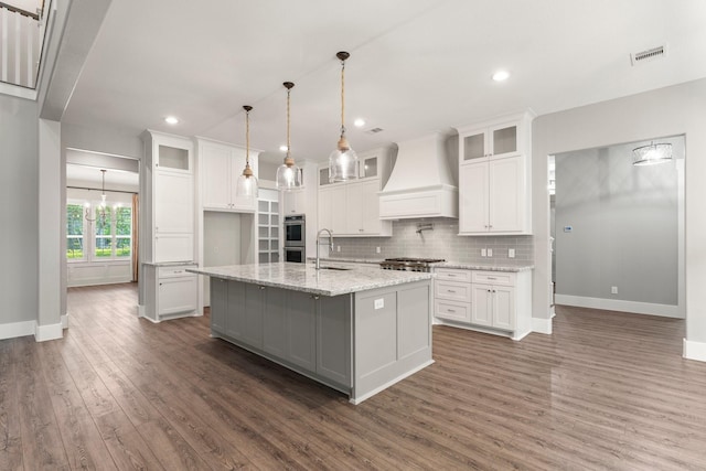 26111 Upper Beacon Pl, Montgomery, TX 77316 - kitchen with dark wood-style flooring, baseboards, visible vents, and custom exhaust hood