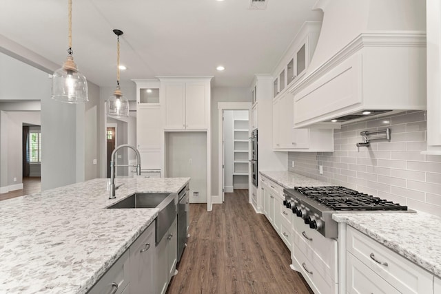 26111 Upper Beacon Pl, Montgomery, TX 77316 - kitchen featuring white cabinets, a sink, premium range hood, stainless steel appliances, and glass insert cabinets