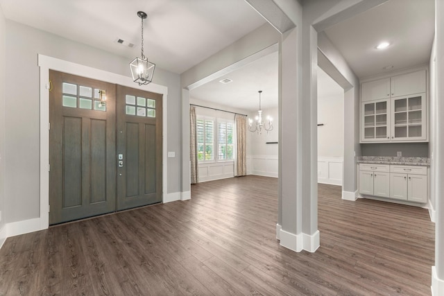 26111 Upper Beacon Pl, Montgomery, TX 77316 - foyer with a chandelier, a wainscoted wall, baseboards, visible vents, and dark wood-style floors