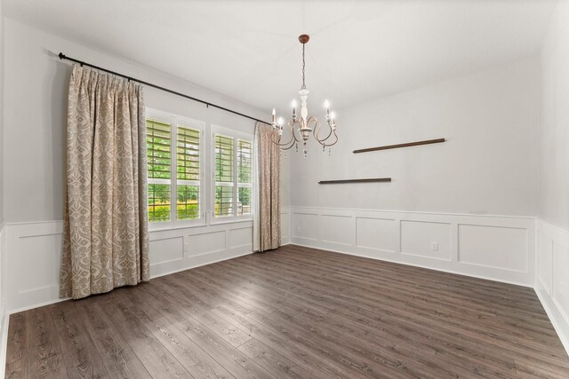 26111 Upper Beacon Pl, Montgomery, TX 77316 - empty room featuring a wainscoted wall, a notable chandelier, wood finished floors, and a decorative wall