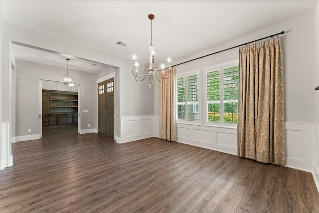 26111 Upper Beacon Pl, Montgomery, TX 77316 - unfurnished dining area with visible vents, a decorative wall, dark wood-style floors, and a chandelier