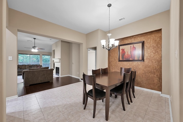 dining area with baseboards, light tile patterned floors, and a fireplace