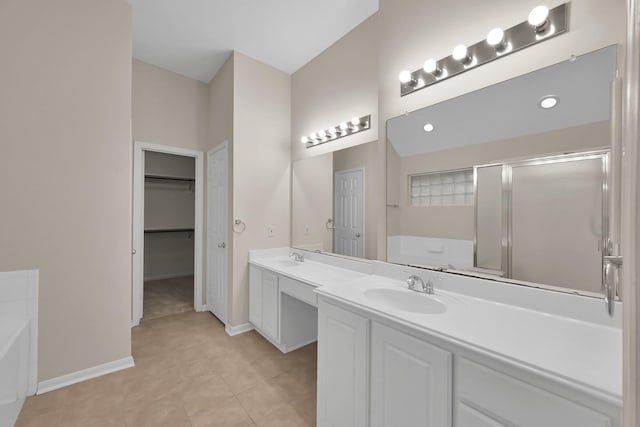 bathroom featuring a sink, double vanity, a shower stall, and a bath
