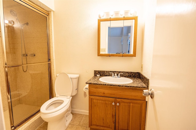 bathroom with tile patterned flooring, vanity, toilet, baseboards, and a stall shower