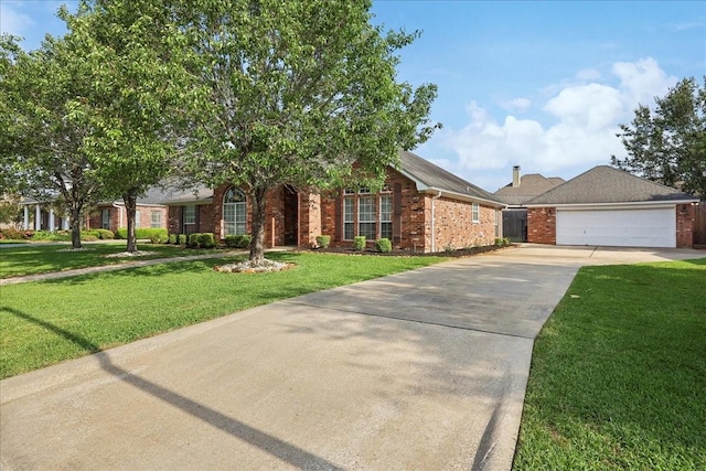 view of front of house with an attached garage, concrete driveway, a front lawn, and brick siding