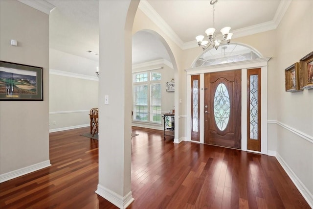 entrance foyer with an inviting chandelier, arched walkways, baseboards, and wood finished floors