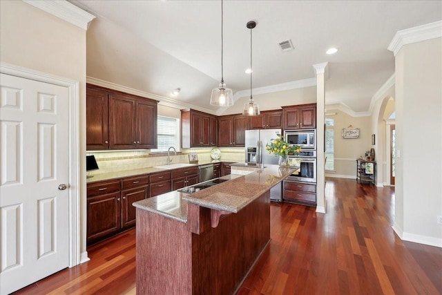 kitchen with appliances with stainless steel finishes, arched walkways, a center island, decorative backsplash, and visible vents