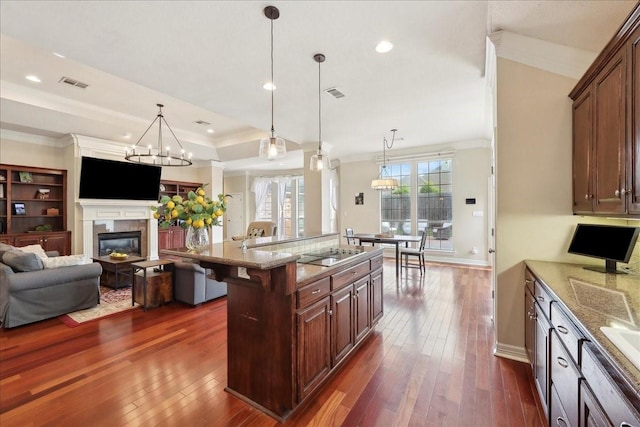 kitchen with visible vents, light stone countertops, a kitchen breakfast bar, black electric stovetop, and dark wood-style floors