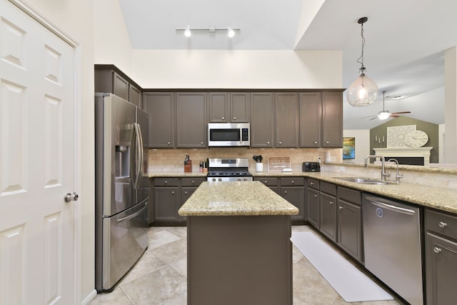 kitchen featuring decorative backsplash, a center island, a sink, appliances with stainless steel finishes, and vaulted ceiling