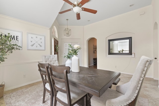 dining space featuring crown molding, arched walkways, baseboards, and a ceiling fan