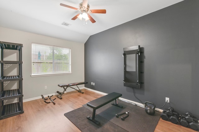 workout area featuring vaulted ceiling, a ceiling fan, wood finished floors, and visible vents