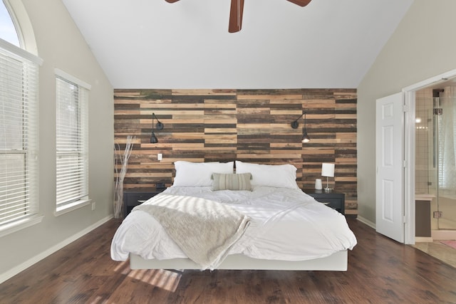 bedroom with high vaulted ceiling, wood walls, multiple windows, and wood finished floors