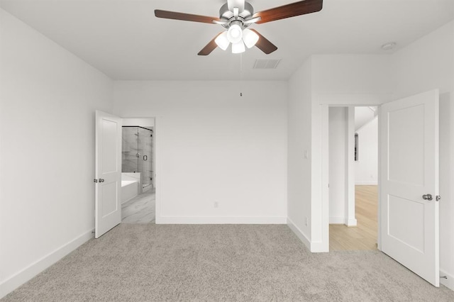 unfurnished bedroom with baseboards, ensuite bathroom, carpet, and visible vents