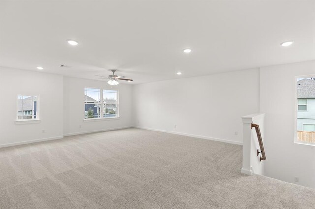 empty room with baseboards, a ceiling fan, recessed lighting, and light colored carpet