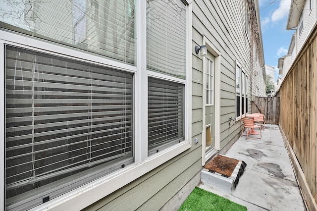 view of side of property with fence and a patio