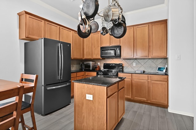 kitchen with wood tiled floor, backsplash, a center island, black appliances, and ornamental molding