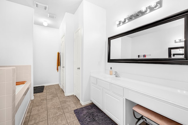 bathroom with tile patterned floors, visible vents, a bath, and vanity