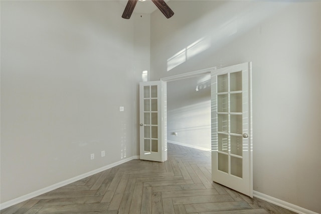 empty room with baseboards, french doors, and ceiling fan