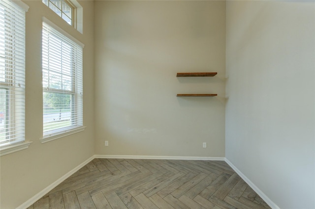 spare room with baseboards and a healthy amount of sunlight