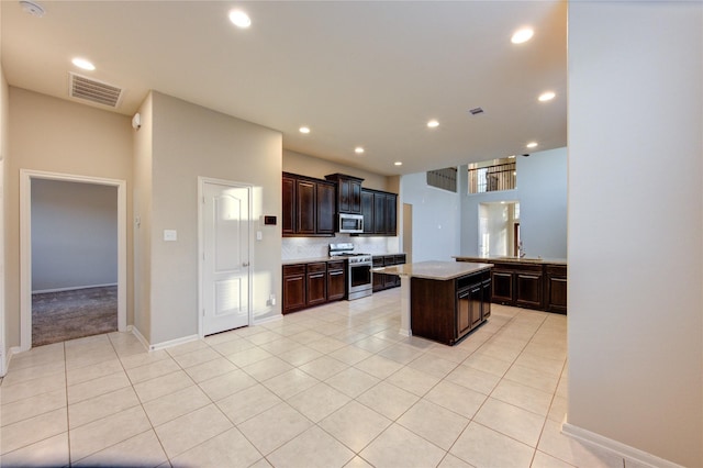 kitchen with recessed lighting, light tile patterned floors, visible vents, a kitchen island, and appliances with stainless steel finishes