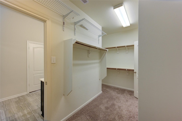 spacious closet featuring light carpet