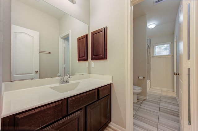 full bathroom featuring toilet, vanity, visible vents, baseboards, and bathtub / shower combination
