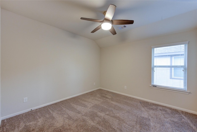 spare room featuring visible vents, baseboards, ceiling fan, light carpet, and lofted ceiling