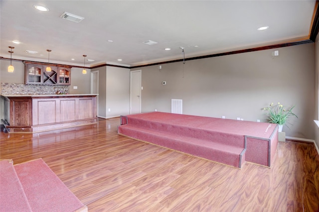 interior space featuring recessed lighting, wet bar, visible vents, and light wood finished floors