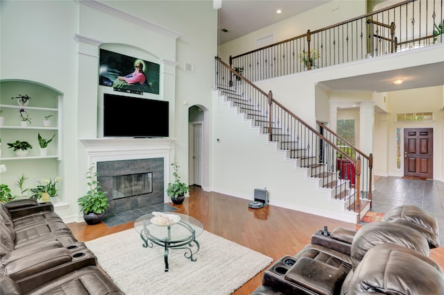 living room with a high ceiling, stairway, and a fireplace