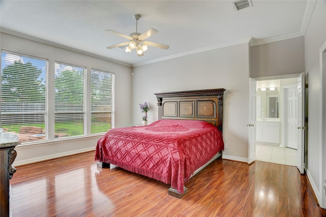 bedroom with visible vents, crown molding, wood finished floors, baseboards, and ceiling fan