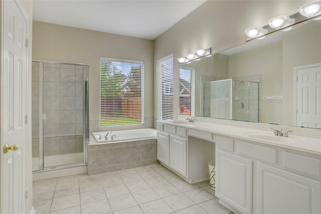 full bathroom featuring double vanity, a bath, tile patterned floors, a sink, and a stall shower